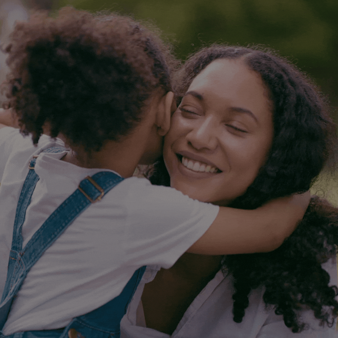 Mãe negra abraçando a filha, representando o acolhimento a mães solo e a diversidade na startup