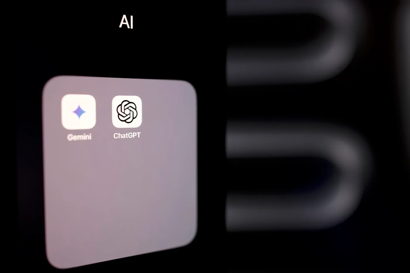 Tela de smartphone exibindo aplicativos de assistentes inteligentes em alto contraste