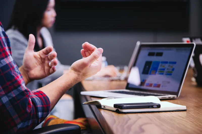 Sala de treinamento corporativo com pessoas aprendendo em laptops