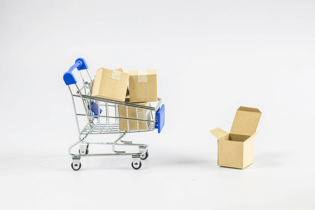 Mini carrinho de compras com caixas dentro representando loja online