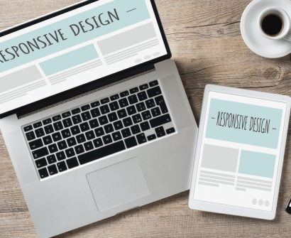 Imagem de um laptop, tablet e smartphone exibindo a mesma página com o texto 'Responsive Design'. A cena destaca a adaptação de desenvolver um site com design responsivo em diferentes dispositivos, incluindo um bloco de notas, óculos e uma xícara de café ao lado.